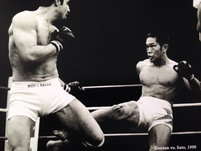 Joel fighting Rumina Sato, Japan 1998. Two martial artists sparring in a ring, black and white photo, intense action, 1998 match.